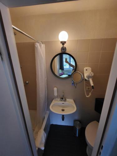 a small bathroom with a sink and a mirror at Hotel Waldrausch in Hahnenklee-Bockswiese