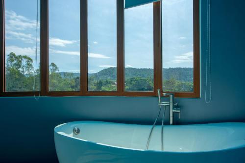 Naung BuaにあるNakaburi Sanctuary Resort&Spaの窓のある客室で、バスタブが備わります。