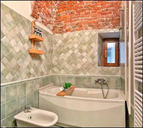 a bathroom with a bath tub and a sink at La Fiaba: bilocale nel centro storico di Cuneo in Cuneo