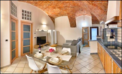 cocina y sala de estar con mesa y sillas en La Fiaba: bilocale nel centro storico di Cuneo en Cuneo