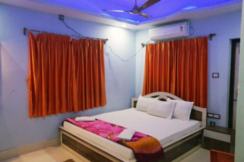 um quarto com uma cama com uma cortina vermelha em Goroomgo Muskan Guest House Digha em Digha