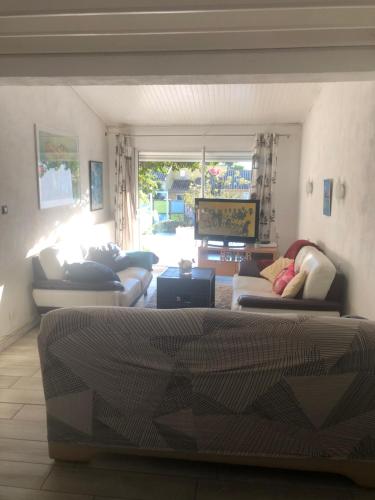 sala de estar con sofás y ventana grande en Les Micocouliers - Spacieuse maison,4chambres ,avec Jardin- Parking -Wifi en Béziers