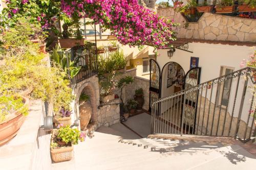 a building with a bunch of plants and flowers at Hotel Condor in Taormina