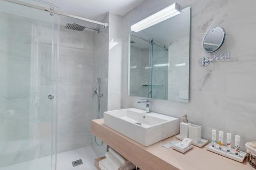 a white bathroom with a sink and a shower at White Loft Syros in Ermoupoli