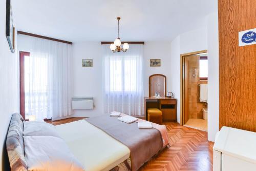 a bedroom with a bed and a desk and a mirror at Apartments by the sea Petrcane, Zadar - 19644 in Petrcane