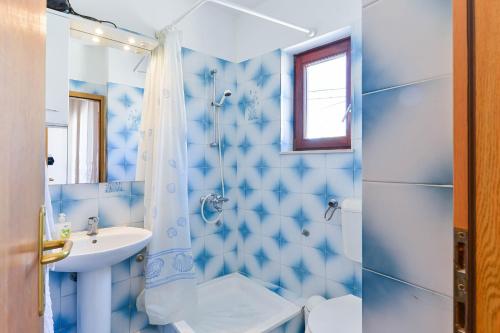 niebieska łazienka z umywalką i prysznicem w obiekcie Apartments by the sea Petrcane, Zadar - 19644 w Petrčane
