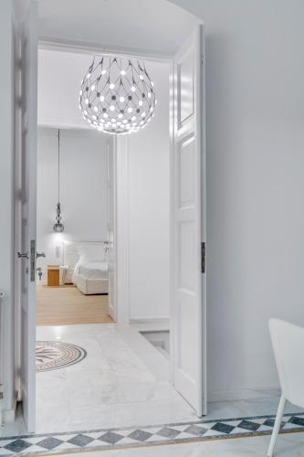 a room with a white door and a chandelier at White Loft Syros in Ermoupoli
