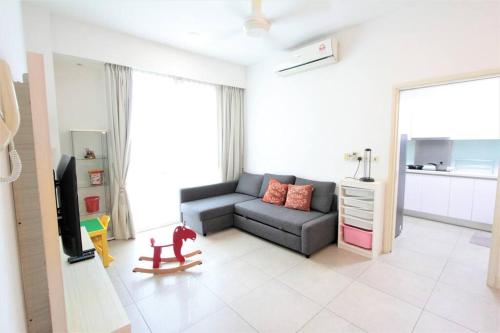 a living room with a couch and a tv at Afiniti Residensi Legoland Medini in Nusajaya