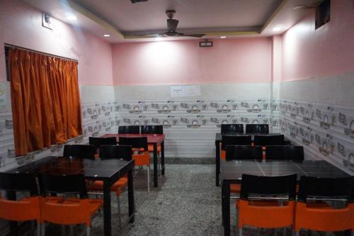 um restaurante com mesas e cadeiras num quarto em Goroomgo Muskan Guest House Digha em Digha