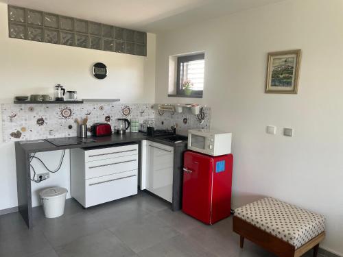 a kitchen with a red refrigerator and white cabinets at Ubytování U Vinice in Mělník