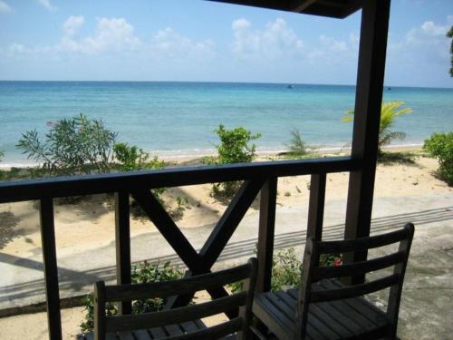a balcony with a chair looking out at the beach at Dumba Bay Tioman in Tioman Island
