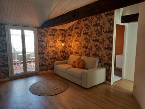 a living room with a couch with a teddy bear on it at Bienvenue à Figeac in Figeac