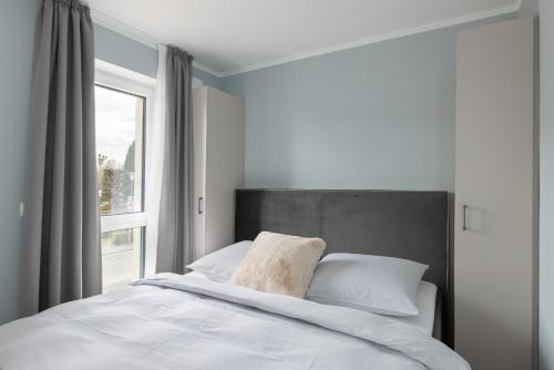 1 dormitorio con 1 cama grande y ventana en Sturmfrei Suite 7 en Scharbeutz