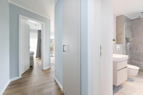 a white bathroom with a toilet and a sink at Sturmfrei Suite 8 in Scharbeutz