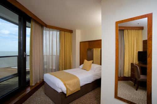 a bedroom with a bed and a window with a view at The View Hotel in Eastbourne