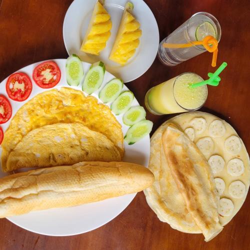 ニンビンにあるAmazing View Homestayのパン、野菜、ドリンクを盛り合わせた料理