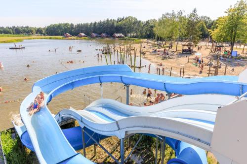 een waterglijbaan op een strand met mensen in het water bij RCN de Flaasbloem in Chaam