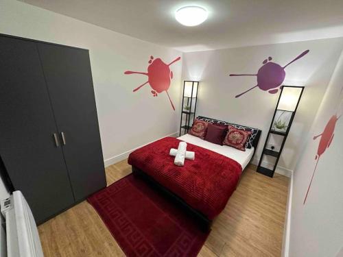 a bedroom with a bed with a red bedspread and two crab decals at Beautiful private detached 1 bed with private outdoor space in Stone Grove