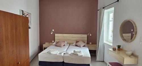 a bedroom with a bed with white sheets and a mirror at FOTA'S HOME in Myrtos
