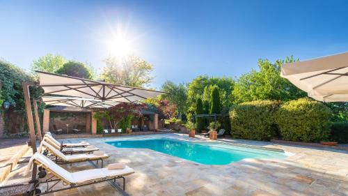 a swimming pool with two chairs and an umbrella at Uvaspina 8, Emma Villas in Antignano