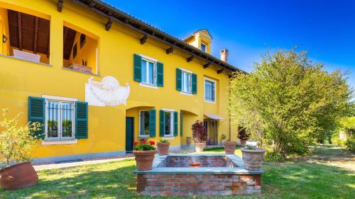 a yellow house with a fountain in the yard at Uvaspina 8, Emma Villas in Antignano