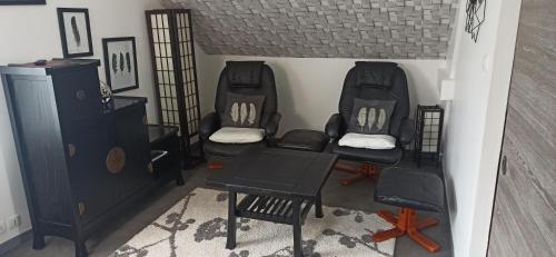 Pokój z 2 krzesłami, stołem i szafką w obiekcie Tout confort et proximité. w mieście Vichy