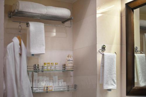 a bathroom with white towels and a mirror at Brij Villa, Dalhousie - A Colonial Luxury Retreat in Dalhousie