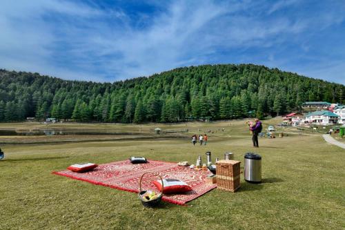 a picnic table on the grass in a field at Brij Villa, Dalhousie - A Colonial Luxury Retreat in Dalhousie
