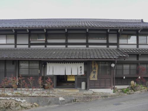 un edificio de estilo asiático con un cartel. en Iroriyado Hidaya, en Takayama