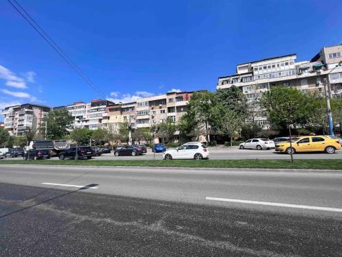 uma rua com carros estacionados num parque de estacionamento com edifícios em CRISTAL Home Boutique Apartment 1 - Confort, Spatios, Linistit, Zona de interes em Craiova