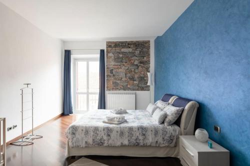 コモにあるMagnifico Appartamento Centro Comoの青い壁のベッドルーム1室、ベッド1台が備わります。