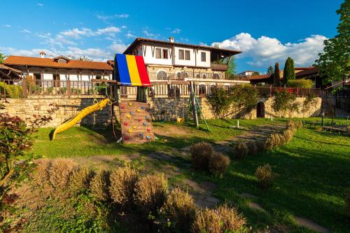 a playground in front of a house with a slide at Rachev Hotel Residence in Arbanasi