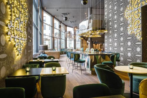 ein Restaurant mit Tischen und Stühlen und eine Bar in der Unterkunft Motel One Brussels in Brüssel