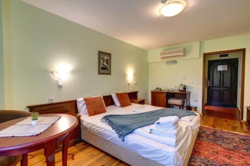 a bedroom with a bed and a table in it at Rachev Hotel Residence in Arbanasi
