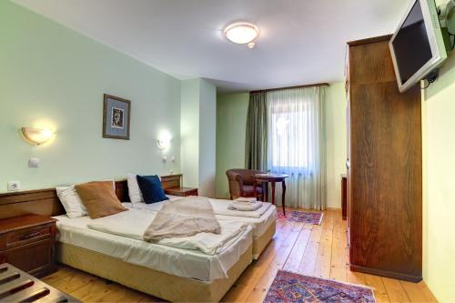 a hotel room with a bed and a television at Rachev Hotel Residence in Arbanasi