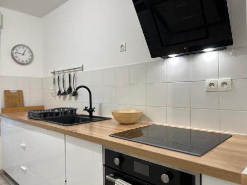 - une cuisine avec un comptoir, un évier et une cuisinière dans l'établissement Grand T2 Centre Ville avec Parking Gratuit, à Toulouse