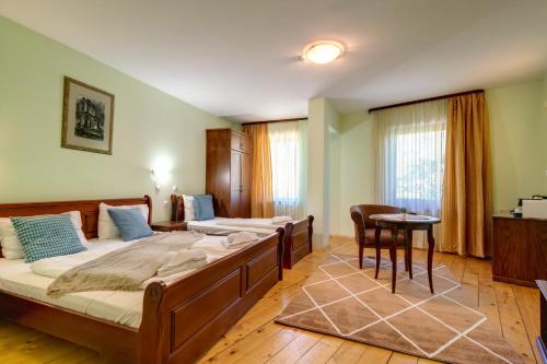 a bedroom with two beds and a table at Rachev Hotel Residence in Arbanasi