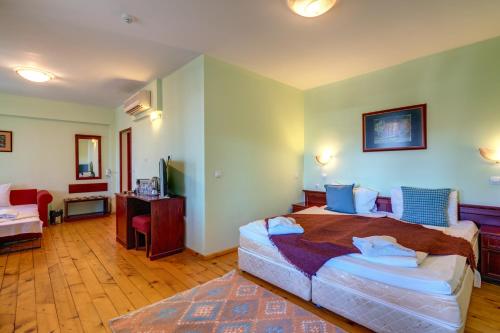 a bedroom with a large bed with blue pillows at Rachev Hotel Residence in Arbanasi