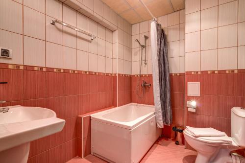 een badkamer met een bad, een toilet en een wastafel bij Rachev Hotel Residence in Arbanasi