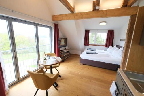 a hotel room with a bed and a table and chairs at Wohlfühloase am Trausdorfberg mit Sauna, Whirlpool und Panorama in Sankt Marein bei Graz
