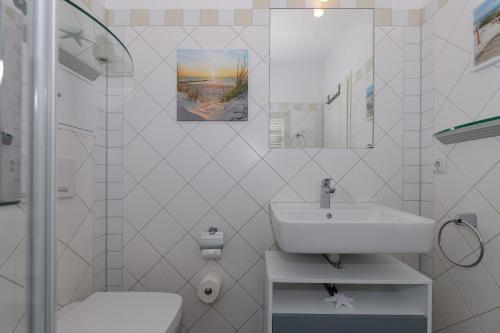 a white bathroom with a sink and a toilet at Villa-Parkblick-Wohnung-26-541 in Kühlungsborn