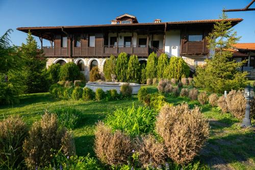 a house with a garden in front of it at Rachev Hotel Residence in Arbanasi