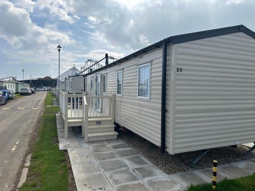 a small white trailer with a porch on a street at Sunnymede E11 Keyshare Holiday lets 8 Berth in Skegness