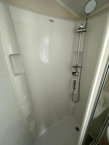 La salle de bains blanche est pourvue d'une douche et de toilettes. dans l'établissement Sunnymede 2 Keyshare Holiday lets, à Skegness