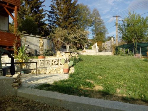 a yard with a fence and a grass field at Káli Apartman in Bakonybél