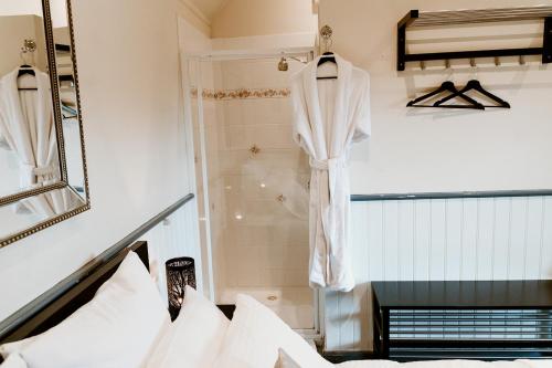 a robe hanging in a shower in a bedroom at The Mountain View Cottage in The Patch