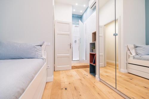 a bedroom with a white bed and a mirror at CasadiMaru in Pietrasanta