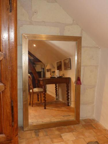 a mirror in a room with a table and a desk at Demeure de Maugé in Saint-Léger-de-Montbrillais