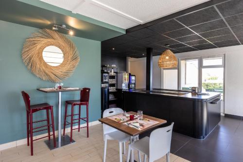 ピュイルボローにあるCampanile La Rochelle Nord - Puilboreau Chagnoletのキッチン(テーブル、椅子付)、