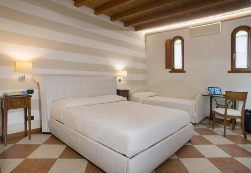 a bedroom with two beds and a table and chairs at Relais Sweet Days in Peschiera del Garda